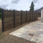 Den nyetablerede carport fik en flot afskærmning ind til naboen med lodrette pilesektioner flettet med pilesorten Kanelpil.