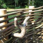 En både smuk og naturlig detalje til håndklderne integreret i det vandret flettede pilehegn i brusekabinen.