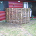 Udendørs brusekabiner er blevet meget populære. Her opført som et flette pilehegn med pilesorten Engelsk Viminalis. Det er en smuk detalje og til stor fornøjelse for hele familien.