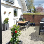 Det lodrette pilehegn med pilesorten Kanel pil står flot og er meget harmonisk til det smukke hus og den hyggelige terrasse.