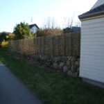 Det vandrette flettede pilehegn med pilesorten Engelsk Viminalis danner en flot ramme mod haven og giver både læ og en god afskærmning mod vejen