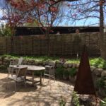 Opdeling med vandret pilehegn mellem 2 haver passer smukt il omgivelserne.