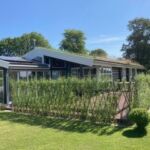 Smukt Belgisk hegn med pilesorten Engelsk Viminalis, omkrandser denne dejlige terrasse i Hundested, som både giver god læ og passer smukt til omgivelserne.