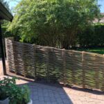 Efter kundens ønske blev pilehegnet her opført med en let faldende højde, så man stadig kan kikke ind i haven fra huset, og skærmer for indkik fra vejen.