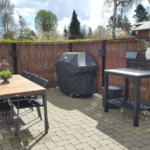 Det lodrette pilehegn indrammer smukt den hyggelige terrasse og som passer meget naturligt til omgivelserne.