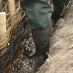 Vandtet bliver ved med at sive ind under det flettede pilehegn.