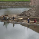 Nogle fletter med pilen, andre henter mere pil til at flette i det vandrette hegn.