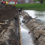 Opsætningen af det vandrette pilehegn udfordres af den høje vandstand.