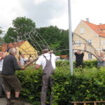 De tunge jernstativer til pilehytten skal løftes på plads.