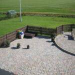 Et idyllisk landsted fik omkranset terrassen med lodrette pilesektioner som skaber læ og udsigten til naturen er bevaret.