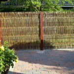 De rødmalede stolper passer flot til pilehgnet og huset.