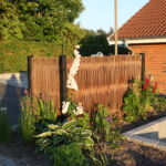 Lodret pilehegn som en flot afskærmning til affaldsspandene .