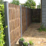 Lodrette pilesektioner her opsat mellem gråmalede stolper som passer perfekt til huset.