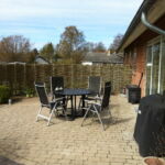 Det buede pilehegn afskærmer for vinden og indkik, men udsigten til haven bevares.