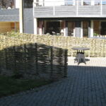 Asymetrisk pilehegn opdeler gårdmiljøet i små hyggelige oaser.