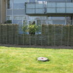 Dejligt pilehegn som både giver udsyn fra stuen og haven og hindre indkik fra vejen. Den galvaniserede låge kan åbnes begge veje.