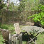 Pilehegnet danner ramme til hyggekrogen på en skøn naturgrund.