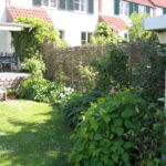 Dejligt pilehegn mellem to dobbetlhuse, hvor højden øges.